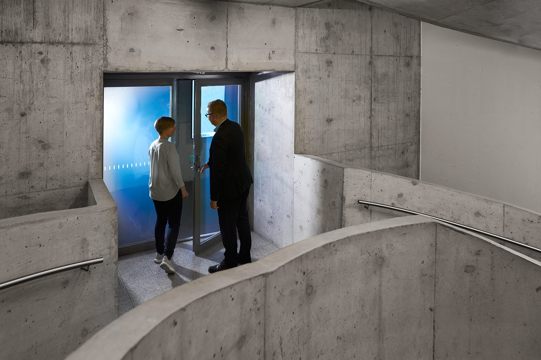 Illustration, två människor vid dörren i grå korridoren.